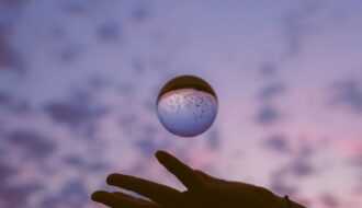 artistic hand with sphere at twilight