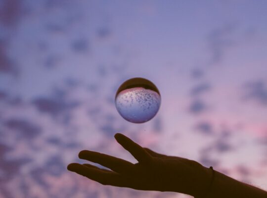 artistic hand with sphere at twilight