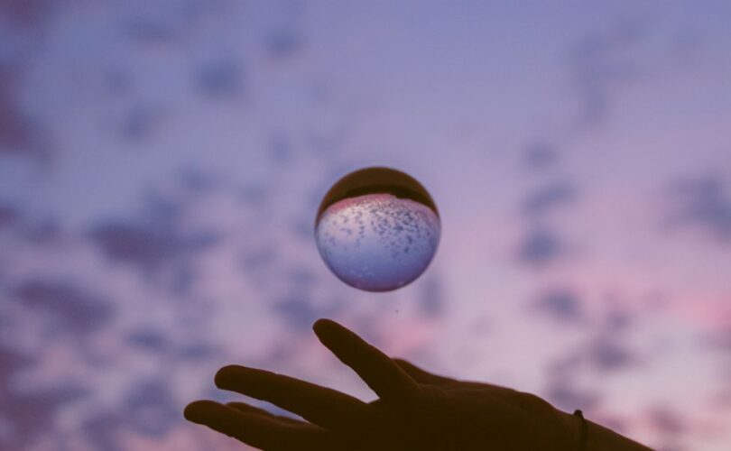 artistic hand with sphere at twilight